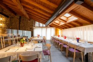 a dining room with tables and chairs and wooden ceilings at Borgo Antico in Albiano