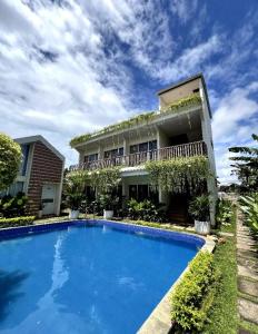 una casa con una grande piscina di fronte a un edificio di Syailendra Hotel Syariah a Jepara