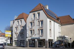a white building with a brown roof at Hotel Domizil in Kornwestheim