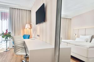 a hotel room with a bed and a desk at NH Vienna Airport Conference Center in Schwechat