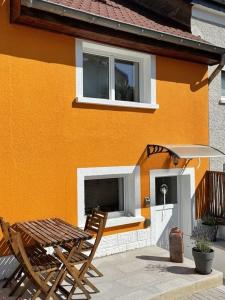 Ein Tisch und Stühle stehen vor einem Haus in der Unterkunft L'Orange in Scheidgen