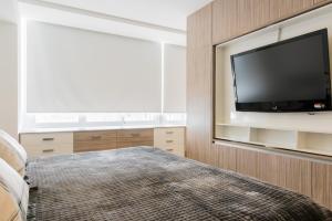 a bedroom with a flat screen tv on a wall at Boutique Apartament Carso Alameda-1002 in Mexico City