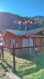 a wooden house with a fence in front of it at Prana sur neltume in Neltume +8 photos