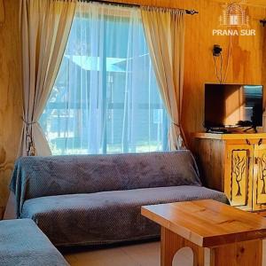 a living room with a couch and a window at Prana sur neltume in Neltume +8 photos