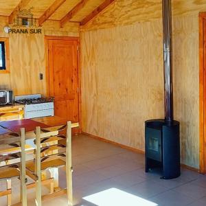 a stove in a kitchen with a table and chairs at Prana sur neltume in Neltume