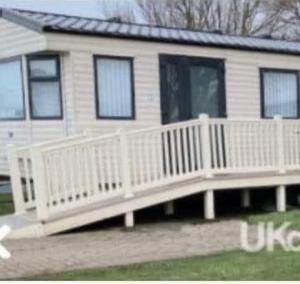a house with a porch with a white fence at Skipsea sands Northfield corner in Ulrome
