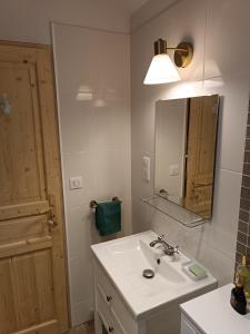 un bagno con un lavandino bianco e uno specchio di le Soleillou - à 10 mn de SARLAT -1151 Route des Endrevies, a La Veyssarie