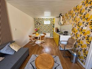 a small living room with a table and a kitchen at Bungalow at the Beach in Noordwijk aan Zee