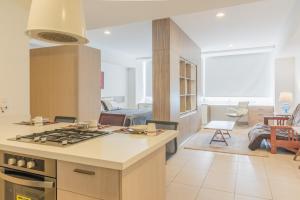 a kitchen with a stove top oven next to a living room at Boutique Apartament Carso Alameda-1002 in Mexico City