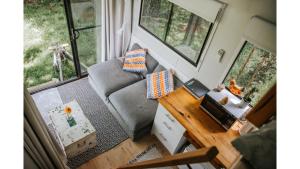 a small living room with a couch and a desk at Bedervale Tiny by Tiny Away in Braidwood +18 photos