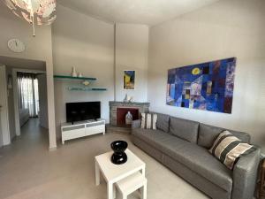 a living room with a gray couch and a fireplace at Sani Villa Miramare in Sani Beach