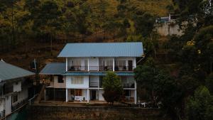 Rock And Mist Munnar في ديفيكولام: منزل على سطح أزرق على تلة