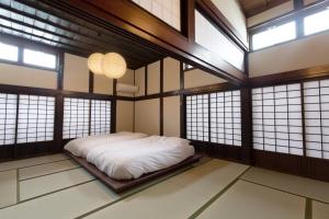 a bedroom with a bed in a room with windows at 雪の家 古澤邸 in Tokamachi