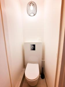 ディジョンにあるLe Buffon - Apt 2 Personnes, 1 ch, Centre villeのライト付きの白いトイレを備えた小さなバスルーム