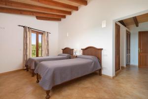 two beds in a room with white walls at Cas Batlet in S'Horta +18 photos