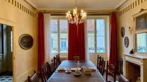 a dining room with a table and red curtains at La Belle Epoque in Époisses