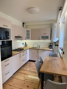 GuciówにあるAgroturystyka Zacisze Guciówの白いキャビネットと木製のテーブルのあるキッチン