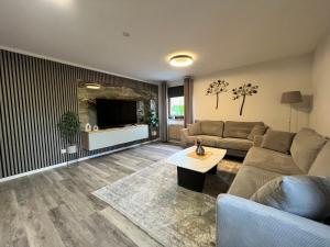 a living room with a couch and a tv at Suite 2 SZ- Lichtenberg in Salzgitter