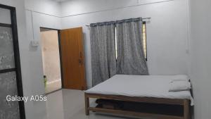 a small bedroom with a bed and a window at VAIBHAV NAIk MADHULI COTTAGE in Alībāg