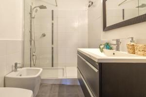 a white bathroom with a sink and a shower at Villa Toni in Stintino
