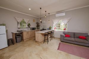 a kitchen and living room with a couch and a table at Le Petit Guesthouse in Bloemfontein