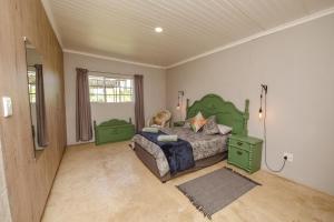 a bedroom with a green bed in a room at Le Petit Guesthouse in Bloemfontein