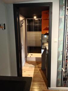 a hallway with a glass door leading to a bathroom at La Villa Saint Ghislain in Thivencelle