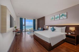岘港Canvas Danang Beach Hotel的一间带大床的卧室和一间客厅