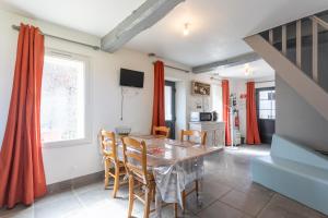 eine Küche und ein Esszimmer mit Tisch und Stühlen in der Unterkunft Gîte les Charmilles in Mont