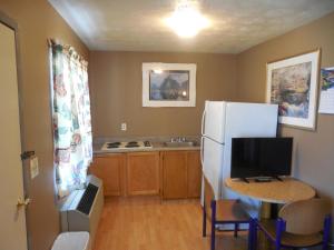 a kitchen with a refrigerator and a table with a computer on it at Ute Motel in Fountain