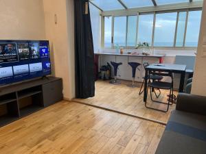 a living room with a television and a table with chairs at A sea-view T2 in a luxury residence for 4 people in Antibes +10 photos