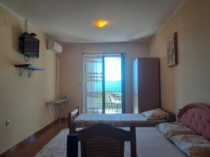 a room with a bed and a couch and a window at Sea View in Tivat