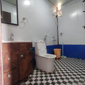 a bathroom with a toilet and a tub and a sink at Kedar Avnita Resort in Gupta Kāshi