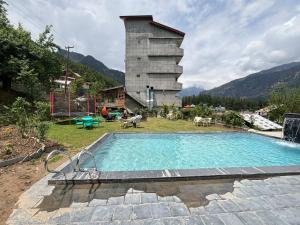 una piscina frente a un edificio en Hotel Old Smugglers with Balcony mountain view AC hot and Cold Near to Hadimba Temple Near to Mall Road#Free Pick from Volvo Bus Stand, en Manali