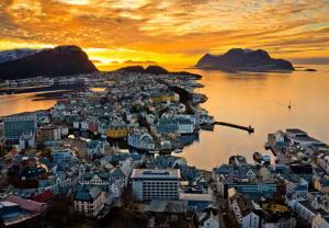 オーレスンにあるÅlesund Campus Apartmentsの夕暮れ時の水上の都市の航空写真
