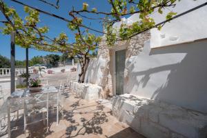 a white building with a table and chairs on a patio at Villa Stellina and Trullo Cecé in Ostuni