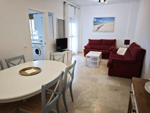 a living room with a white table and a red couch at Vista al Mar con Terraza - Costa Ballena Apartamento primera linea de playa in Costa Ballena