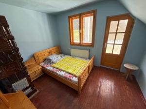 a small bedroom with a bed and a window at Cabana Valea Lungă in Telcişor