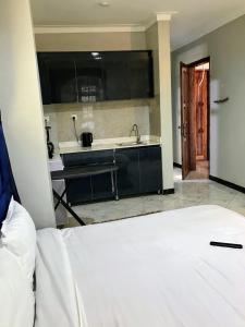a kitchen with a bed and a sink in a room at Yazmin's Bright Studio with Fast Wi-Fi & Parking in Kampala