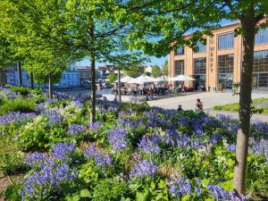 a garden with purple flowers in front of a building at BetterBeds BRB - Apartment - Zentral - Smart TV - Küche - WLAN in Brandenburg an der Havel +8 photos
