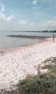 a person standing on a beach near the water at The Beach House in Schellinkhout