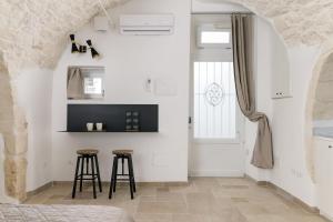 una camera con un letto e due sgabelli da bar di SKYBLU by Wonderful Italy a Ostuni