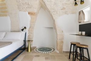una camera con un letto e due sgabelli di SKYBLU by Wonderful Italy a Ostuni