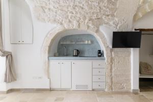 una cucina con bancone bianco e arco di SKYBLU by Wonderful Italy a Ostuni