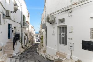 un vicolo in un centro storico con edifici bianchi di SKYBLU by Wonderful Italy a Ostuni
