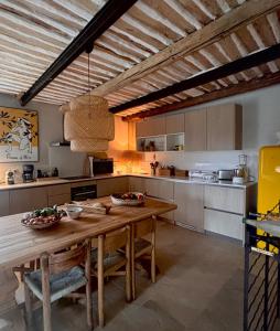 a large kitchen with a wooden table and chairs at Brin d'Olivier en Luberon in Gargas