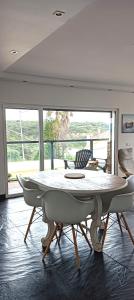 a dining room with a table and chairs in a room at Zambujeiraseahouse - 100m da praia in Zambujeira do Mar