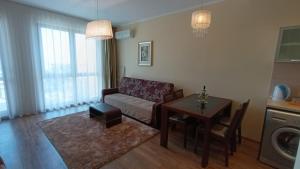 a living room with a couch and a table at Apart Hotel Golden Line private apartments in Golden Sands