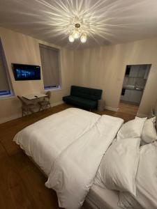 um quarto com uma grande cama branca e um sofá em Peckham Haven em Londres