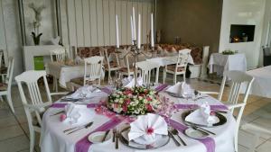 a dining room with white tables and white chairs at Hotel-Restaurant & Metzgerei Rößle in Dettingen an der Erms